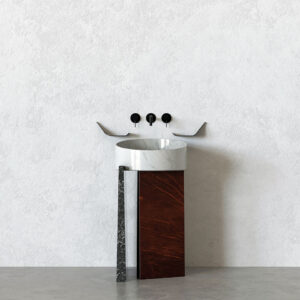 Full view of the EGO washbasin: a white-veined marble bowl on a sculptural pedestal combining a dark stone side and a red-brown veined marble front, with matte-black wall-mounted controls on a textured light wall.