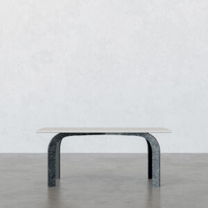 Front view of the Incontro dining table with a light marble top and two curved dark-veined marble legs, photographed in a minimal studio setting.